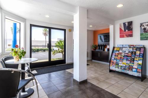 a lobby of a hotel with a table and chairs at Motel 6-Anaheim, CA - Fullerton East in Anaheim