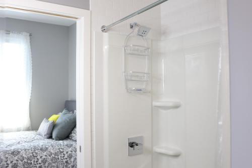 a white bedroom with a bed and a window at Location, Location, Location-Immaculate 1 Bedroom Suite in Victoria