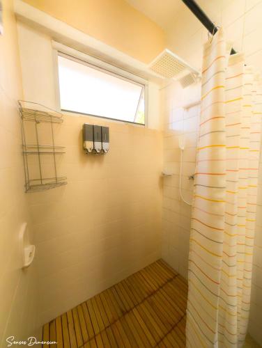 a bathroom with a shower and a window at Senses Dimension - Ipioca Beach Suites in Maceió