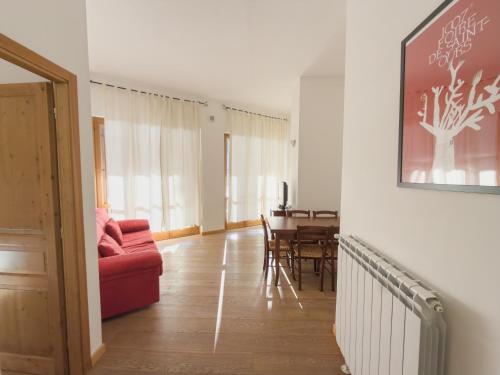 a living room with a red couch and a table at Bilocale sulle piste da sci in Pila