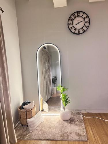 a room with a mirror and a clock on the wall at Designer 1 bedroom , self check-in , pool & sauna in Rawalpindi