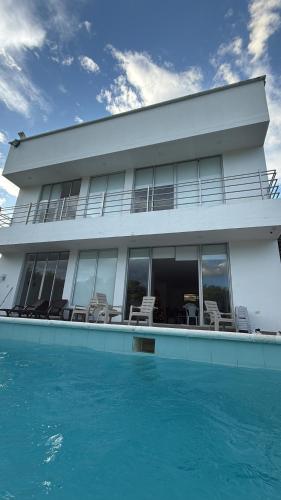 a house with a swimming pool next to the ocean at Casa HOTEL campestre TranKilandia in Rivera