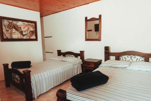 a room with three beds and a mirror at Chalet Alto Bonito in Pueblorrico
