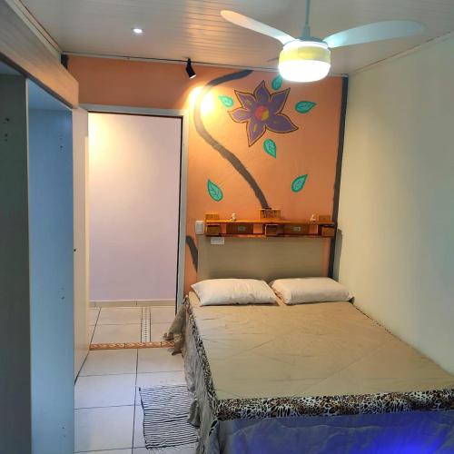 a room with a bed and a painting on the wall at Casa Recanto do Baiano in Balneário Gaivotas