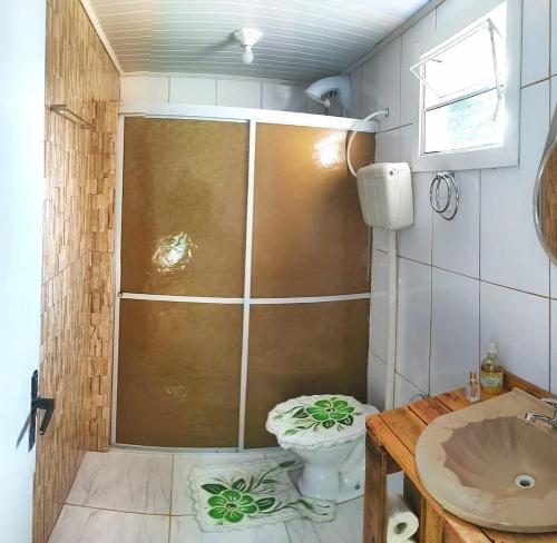a bathroom with a shower with a toilet and a sink at Casa Recanto do Baiano in Balneário Gaivotas
