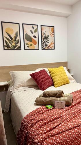 a bed with colorful pillows on it in a bedroom at Studio Congonhas I SP Expo I Morumbis & Interlagos in São Paulo