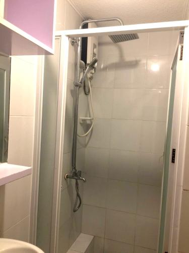 a shower with a glass door in a bathroom at Janna's Condo Hotel in Cebu City