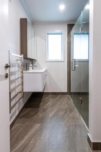 a white kitchen with a sink and a shower at Spacious 3BR with 2 carpark in Lincoln
