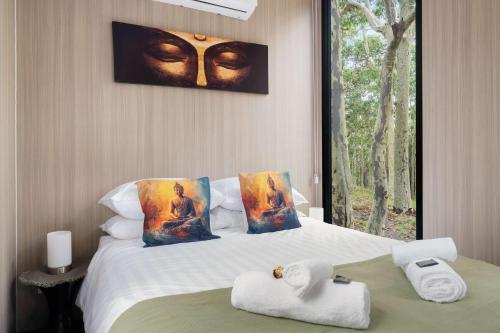 een hotelkamer met een bed met handdoeken erop bij Inana Shanti by Tiny Away in Cooranbong