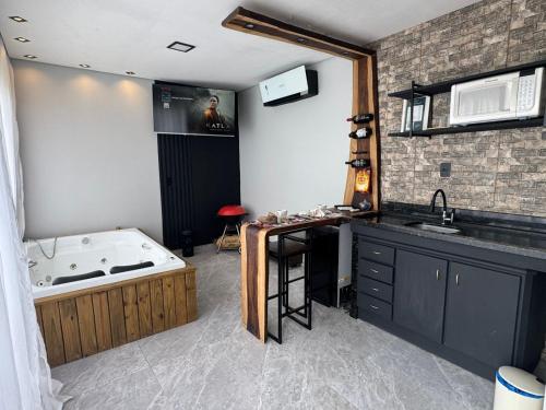 a bathroom with a tub and a sink at Chalé Refugio nas montanhas in Guaratuba