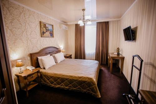 a hotel room with a bed and a television at Aristokrat in Vinnytsya