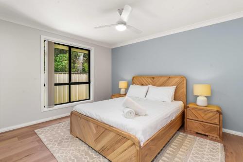 a bedroom with a bed and a window at White Sands Villa by Experience Jervis Bay in Huskisson