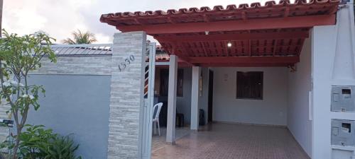 een pergola aan de zijkant van een huis bij Casa temporada Guriri Regi 2 in São Mateus