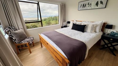 Un dormitorio con una cama grande y una ventana. en Fantail Hill, en Thames