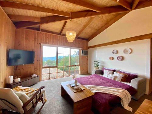 a bedroom with a large bed and a large window at Mountain View Spa Cottage in The Basin