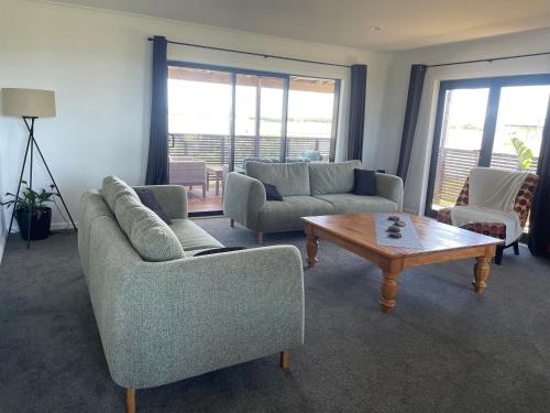 a living room with couches and a coffee table at Te Awa Holiday Home in Napier