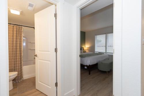 a bedroom with a bed and a bathroom at Roark Home Suites - Branson Landing, Gym, Indoor Pool in Branson