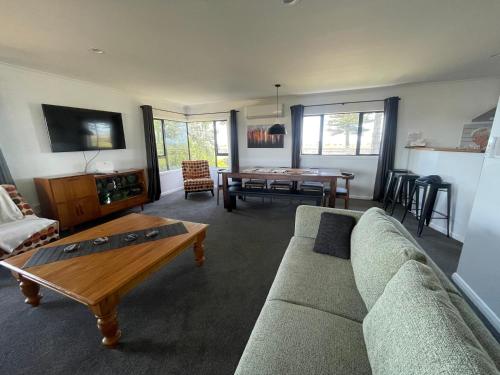 a living room with a couch and a table at Te Awa Holiday Home in Napier
