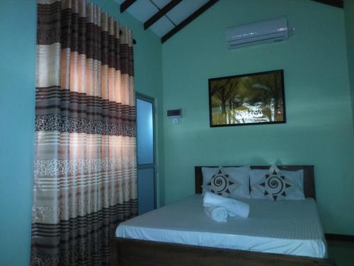 a bedroom with a bed and a window at Illumination Stay in Negombo