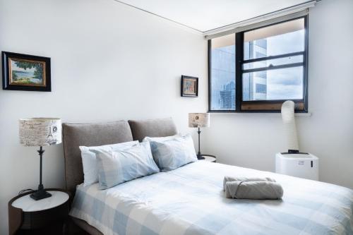 a bedroom with a large bed with a window at Central CBD High-Level Apartment with Views in Sydney