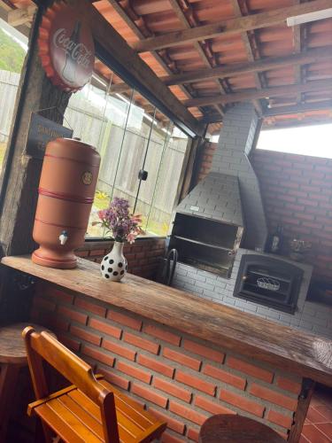a kitchen with a brick wall and a stove at Casa da Cuca in Nova Friburgo