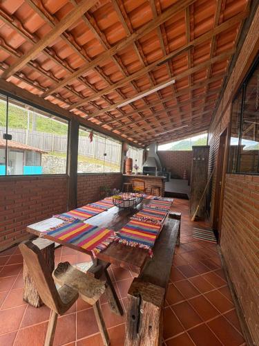 a large wooden table with benches in a room at Casa da Cuca in Nova Friburgo
