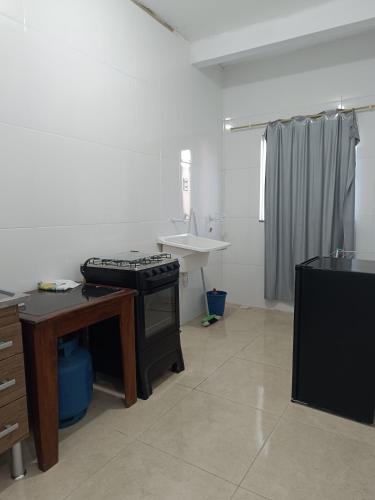 a kitchen with a stove and a sink at Kitnet amplo in Santa Cruz Cabrália