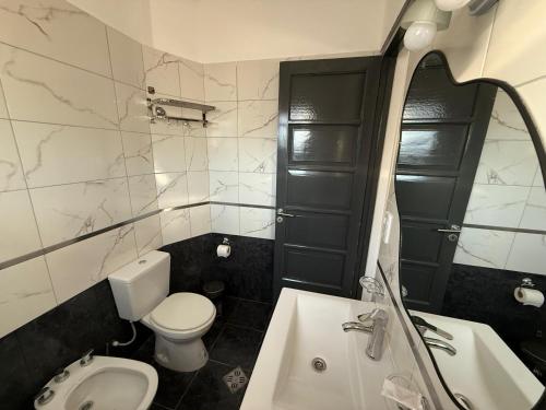 een badkamer met een wit toilet en een wastafel bij Apart's Sobremonte - Deptos Modernos in Rio Cuarto