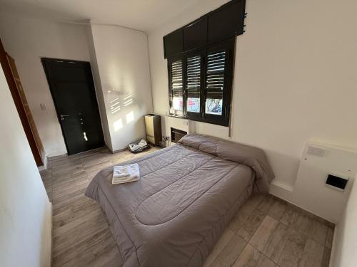 een kleine slaapkamer met een bed en een raam bij Apart's Sobremonte - Deptos Modernos in Rio Cuarto