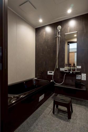 a bathroom with a bath tub and a sink at PREMIUM O2stay citrus onomichi in Onomichi