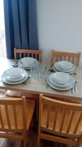 a dining room table with plates and glasses on it at City Sparrow - Upper Pad Nest in London