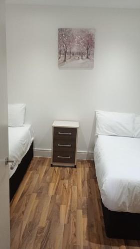 a bedroom with two beds and a wooden floor at City Sparrow - Upper Pad Nest in London
