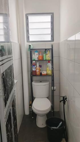 a bathroom with a toilet with a shelf above it at MiniHaus2Stay in Pulau Sebang