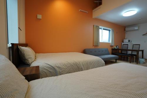 a hotel room with two beds and a chair at Style Room in Osaka
