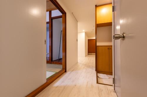 an open door to a hallway with a mirror at Tourist Hotel New Aoki 観光ホテル ニュー青木 in Tokyo