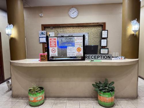 un bancone della reception in una hall con un orologio sul muro di Hotel Royal Blue & Golf Cart Rental a San Pedro