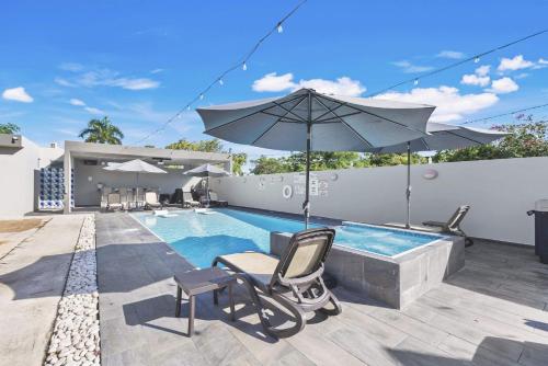 ein Swimmingpool mit zwei Stühlen und einem Sonnenschirm in der Unterkunft Aquaville Dorado Moderna Studio 6 in Dorado