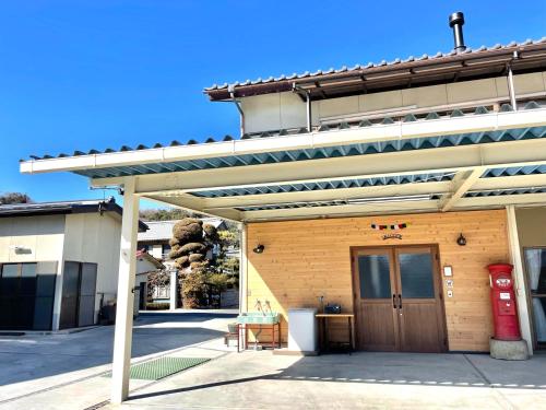 a building with a wooden door and a red mail box at 民泊Nao in Minami Alps