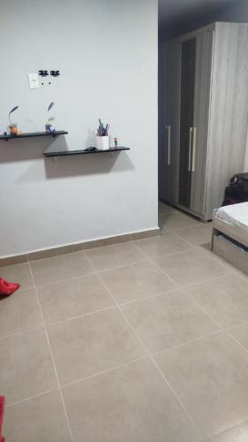 a room with a tile floor and a white wall at Aconchego da Maria 2! in Mangaratiba