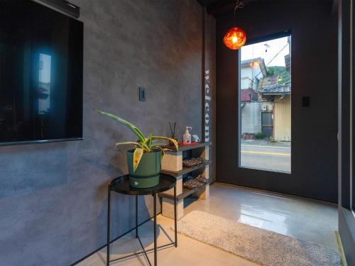 a hallway with a table with a plant on it at Rino-Haku 03 in Anan