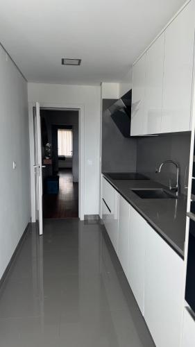 a kitchen with white cabinets and black counter tops at Casa DOURO-PORTO in Valbom
