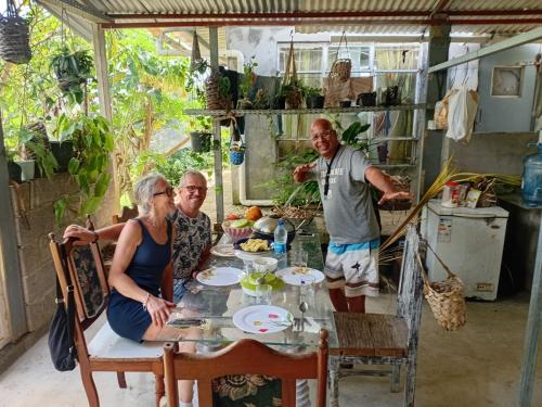 a group of people sitting at a table in a kitchen at Rootscamp in Surinam