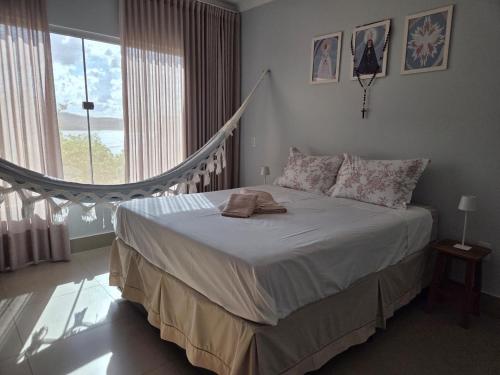 a bedroom with a bed and a large window at Rancho dos Ipês Corumbá in Alexânia