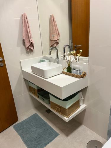 a bathroom with a white sink and a mirror at Rancho dos Ipês Corumbá in Alexânia