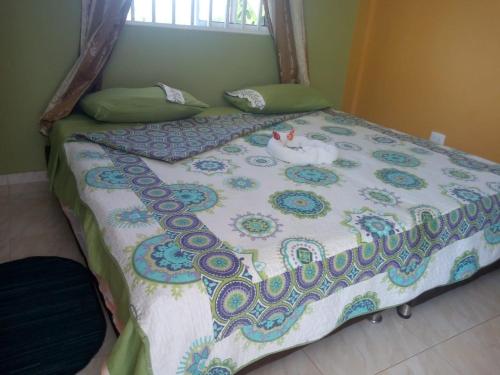 a bed with a quilt with a chicken on it at habitacion doble 1 Marcia place in San Andrés