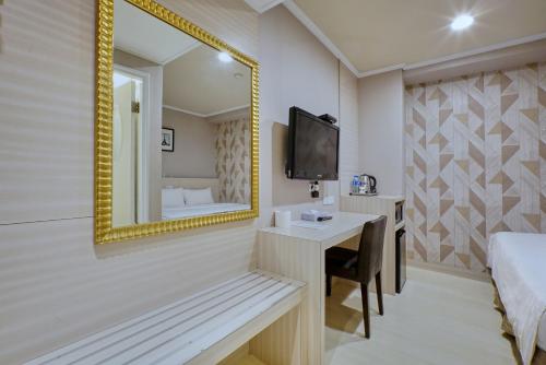 a hotel room with a mirror and a bed and a desk at Golden Stone Hotel in Kaohsiung