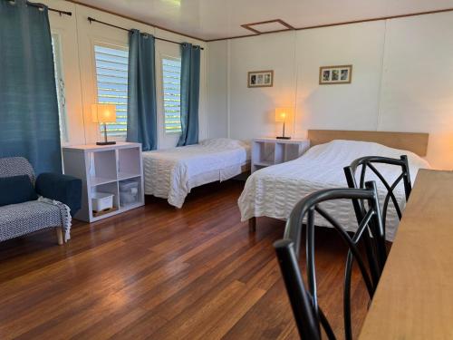 een kamer met twee bedden en een tafel en stoelen bij Horse Cottage in Sarteneja