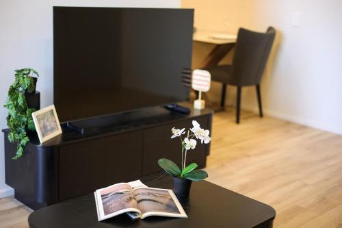 a living room with a table and a tv at VTA - Modern 1BR Apt in the Heart of Adelaide in Adelaide