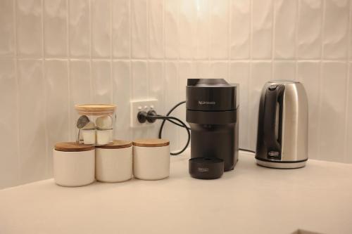 a coffeemaker and a coffee maker on a counter at VTA - Modern 1BR Apt in the Heart of Adelaide in Adelaide