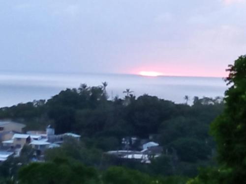 a sunset over the ocean with houses and trees at habitacion doble 1 Marcia place in San Andrés